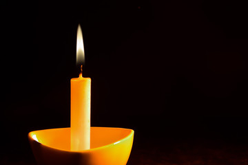 Glowing candle on the dark background