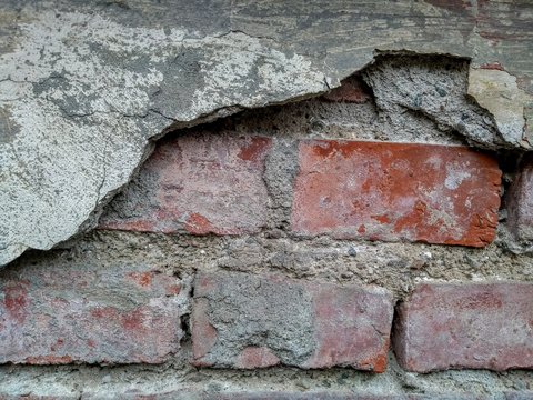 old brick wall with weathered plaster