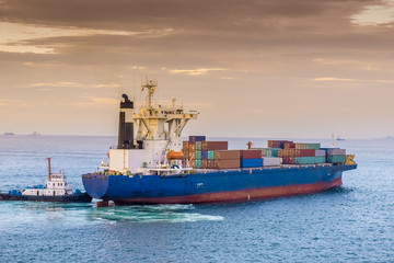 Close view of big container ship arriving at port ready to berth. Port terminal. 