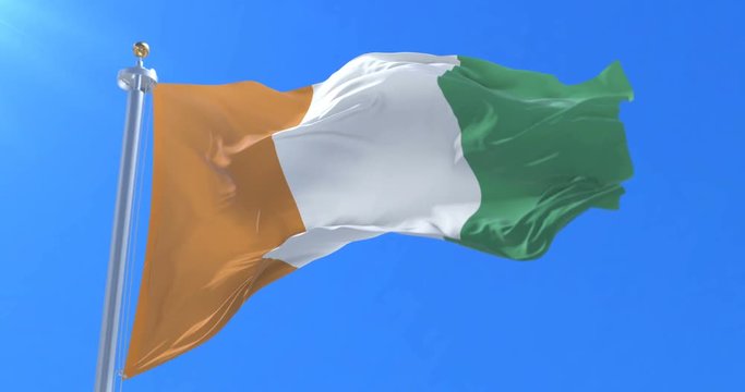 Flag of Ivory Coast or C&ocirc;te d'Ivoire waving at wind with blue sky in slow, loop