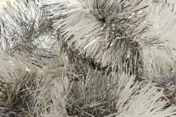 Abstract festive image in silver tone for Christmas or Happy new year background. Close up of hanging holiday tinsel garland.