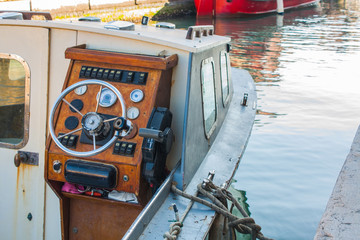 Fototapeta na wymiar Helm of a boat, vintage wooden navigation panel with steering wheel