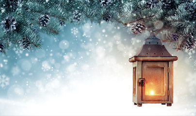 Christmas background with spruce branches and wooden lantern.