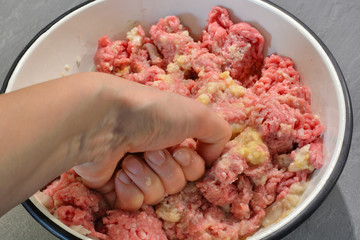 Women's hands mixing  minced meat. 