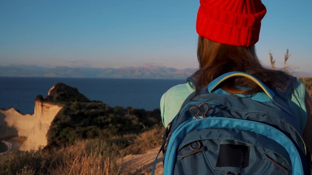 Woman with a backpack goes to the Cape Drastis at Corfu island in Greece