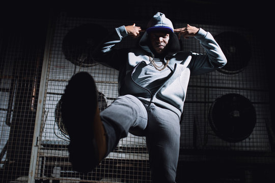 Modern rapper dancing in garage. Urban lifestyle, hip hop.