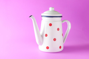 White home decorative polka dot kettle on pink background