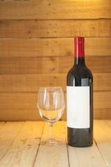 Red wine bottle with empty glass and white label for branding communication