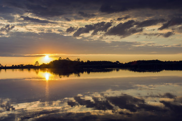 Fototapeta na wymiar Sunset and clouds by the lake