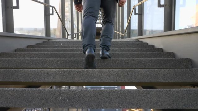 man's feet walking up stairs