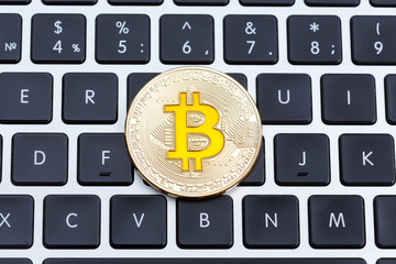 Golden cruptocurrency bitcoin, yyellow bitcoin on computer key board.