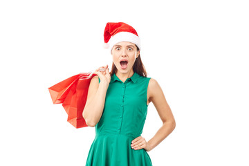 Studio portrait of young woman in Santa hat posing with shopping bags on white background