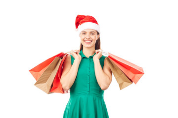 Studio portrait of young woman in Santa hat posing with shopping bags on white background