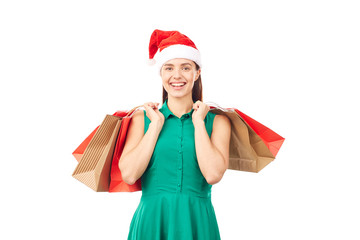 Studio portrait of young woman in Santa hat posing with shopping bags on white background