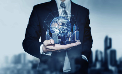 Businessman holding buildings with global network connection. Elements of this image are furnished by NASA