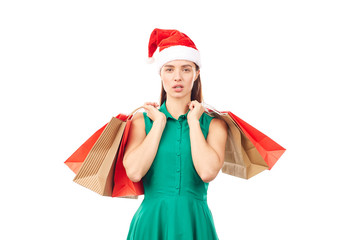 Studio portrait of young woman in Santa hat posing with shopping bags on white background