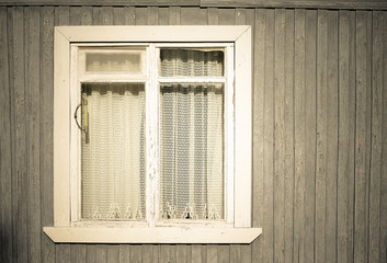 Window on the old wooden houses painted wall. Toned