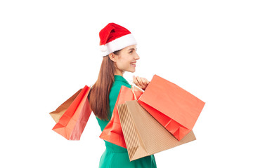Studio portrait of young woman in Santa hat posing with shopping bags on white background