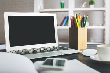 Creative desktop with blank laptop screen