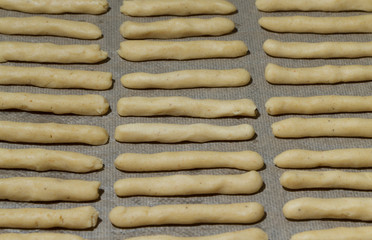 Fresh unbaked cheese sticks on a baking paper for background