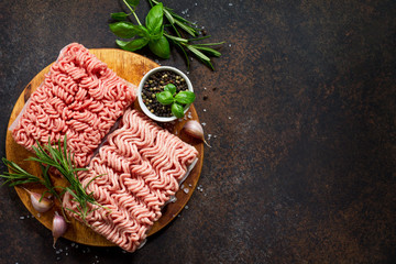 Assorted minced pork and beef with fresh leaves of rosemary and basil. Top view with copy space.