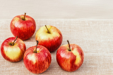 Ripe red-yellow apples lying on a light background.