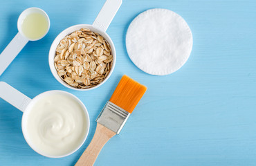 Sour cream (greek yogurt), rolled oats and olive oil in a small plastic scoops - ingredients for preparing diy masks, scrubs and moisturizers. Homemade cosmetics. Top view, copy space.