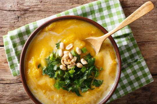 Thai pumpkin soup with coconut milk and peanuts close-up. horizontal top view