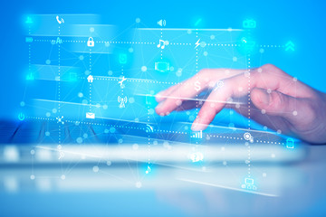 Hand pressing keyboard with high tech media icons