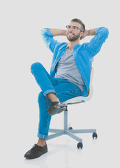 Young man sitting on the chair isolated over white background. Startupper. Young entrepreneur.