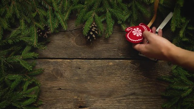 Women's hands create a Christmas decor. Christmas tree branches with cones and christmas decorations on wooden texture ready for your design