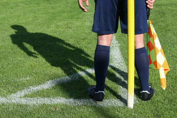 Linienrichter mit Schattenwurf an der Eckfahne