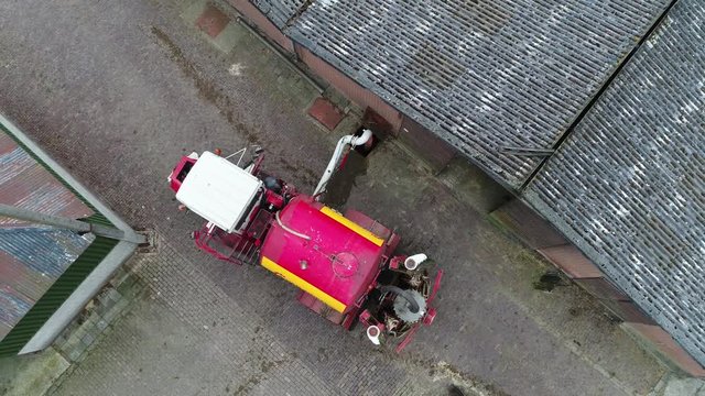 Aerial top down view of manure injector agricultural machine loading manure to fertilize grassland injecting underground which is used as organic fertilizer in agriculture and better for environment
