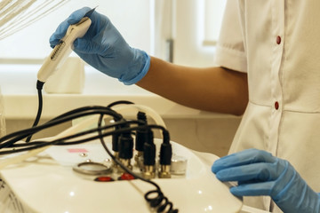The girl beautician conducts the procedure in the beauty salon.