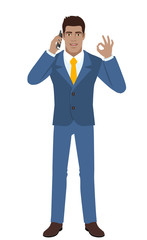OK! Businessman talking on the mobile phone and showing a okay hand sign