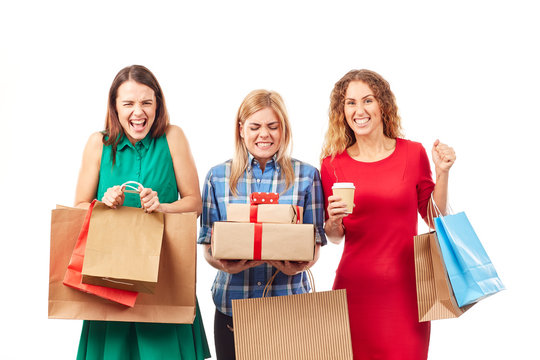 Portrait of three shopaholic girlfriends holding shopping bags and gift boxes