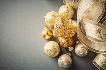 Golden Christmas Ornaments with Satin Ribbon on Gray Background