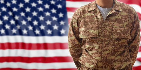 Soldier in an American military digital pattern uniform, standing on a USA flag background