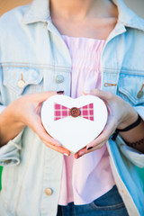 Female hands holding gift box in shape of heart in her hands