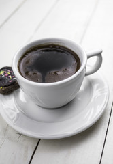 Cup of coffee on white wooden table