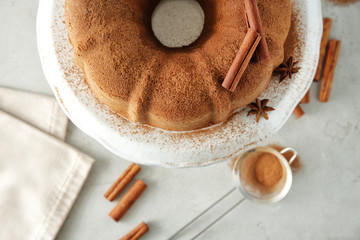 Ceramic stand with delicious cinnamon cake on table