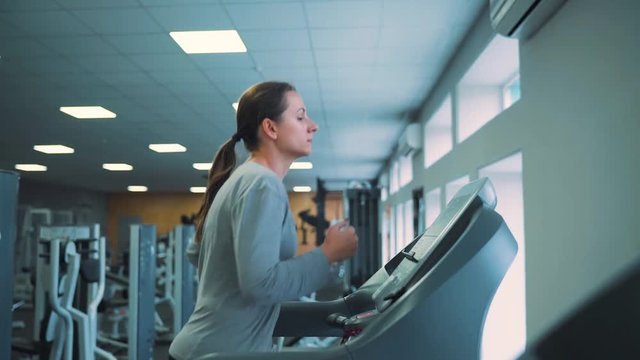 Woman running on treadmill in gym