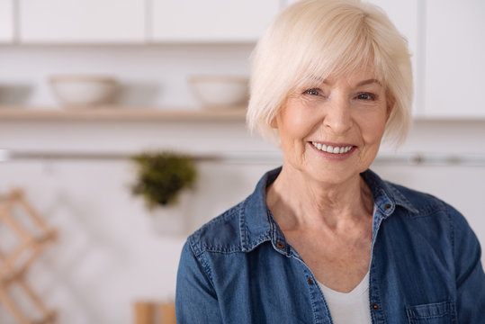 Positive senior woman smiling in the kitchen