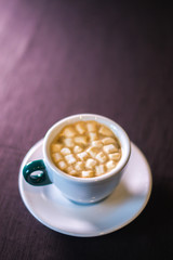 Coffee in cafe with marshmallow with blurred background.