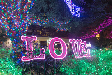 Shining LOVE text from bright bulb light of Christmas glowing neon. Holiday element design.