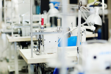 Workplace of tailor or dressmaker with sewing-machine and lamp