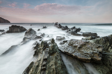 rompen las olas en la cola el dragon , en la costa asturiana