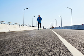 Healthy senior man working out on roadway of the city at leisure