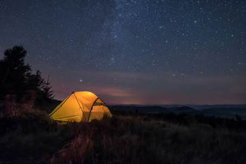 iluminated tent under stars - Powered by Adobe