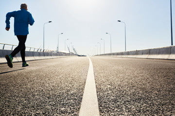 Central line of cycling road in perspective and sportsman jogging along